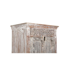 Tall cabinet made from reclaimed doors & panels with a white wash patina showing the close up of the carved wood arhitrave on the top and detail of the side panel