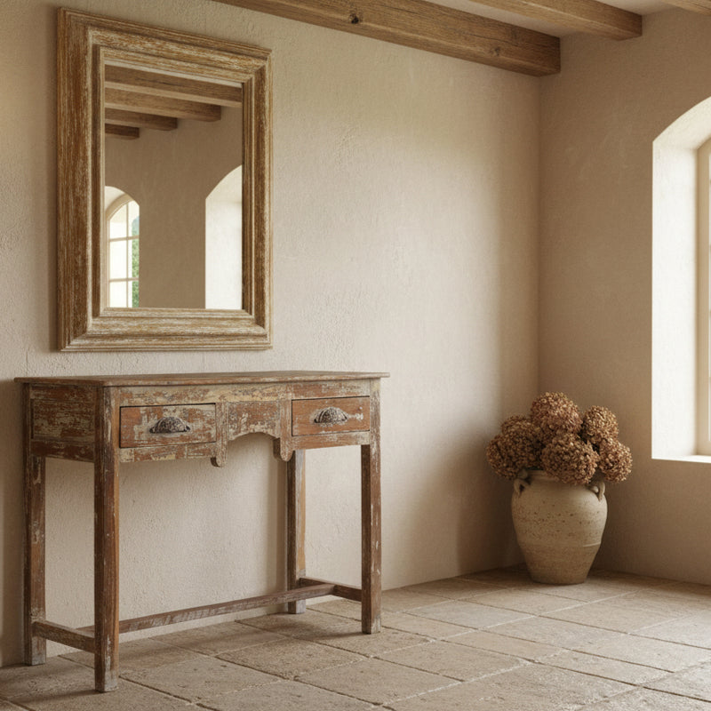 Vintage wooden console table with a distressed in a french country style hall with a mirror above
