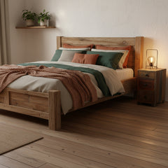 A rustic three-drawer wooden nightstand or end table made from reclaimed wood, featuring a weathered brown and beige finish with dark metal drawer pulls, shown in a rustic bedroom
