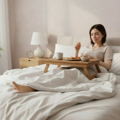 woman in a bed having breakfast on the folding table