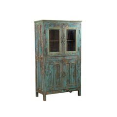 A rustic distressed wooden cabinet with a turquoise and brown weathered finish, featuring two upper glass-paneled doors and two lower solid doors, shown on a plain white background.