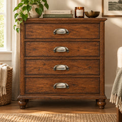 A small antique-style metal cabinet pull handle with a textured, distressed finish, shown on an antique chest of drawers.