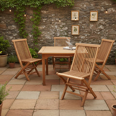 Wooden folding chairs against a stone wall, around a square table in a patio