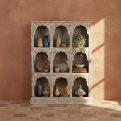 Wooden shelf with arch-shaped compartments on a terracotta wall