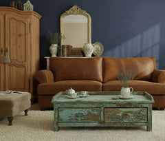 Vintage-style wooden coffee table with peeling paint finish in a shabby chic living room