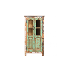 A rustic, distressed wooden cabinet with a weathered green and brown paint finish, featuring two glass-paneled doors and dark metal handles, on a white background