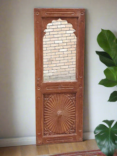 Old  window frame in natural wood with the top part being a mirror and the bottom part carved in a rosace design.