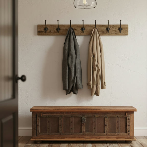 wooden long narrow trunk in a hallway with a coat hangers above