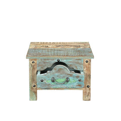 Small side table or bedside locker handcrafted from reclaimed wood with a blue patina. It has one front ornate drawer with rivets, showing drawer open.