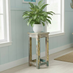 Wooden stool with a distressed finish in a room with a pot plant on top on a light blue background