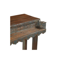Wooden console table with hand carved top on a white background, showing the detail of a horse head corner.