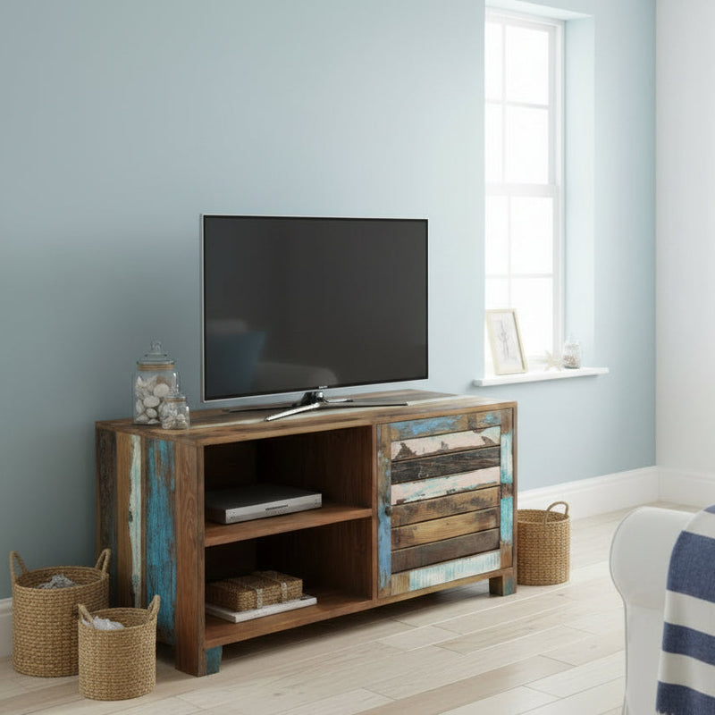 Wooden TV stand in colourful reclaimed wood in a coastal style living room with a TV on a light blue wall
