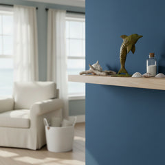 green metal dolphin on a shelf against a blue wall