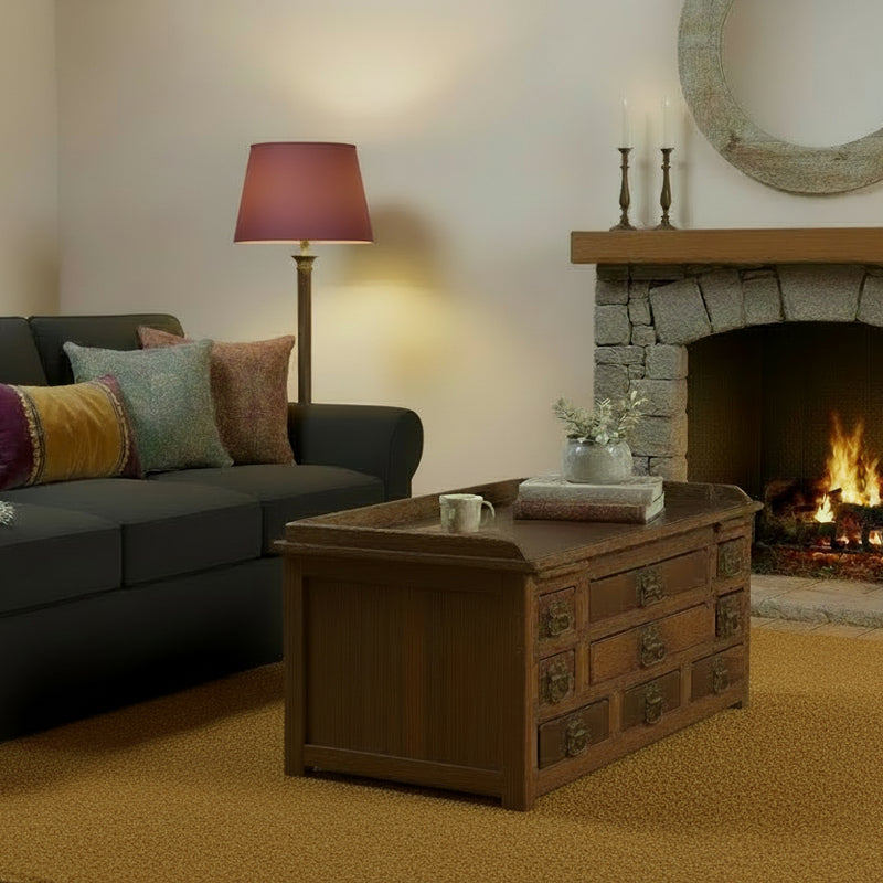 Teak vintage coffee table with multiple drawers in a living room in front of a dark grey sofa 