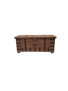 A rustic wooden chest with dark brown accents and a metal lion emblem on the front on a white background