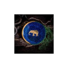 Blue ceramic with gold elephant engraving on a dark background