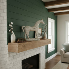 white metal horse on a mantle piece on a dark green wall