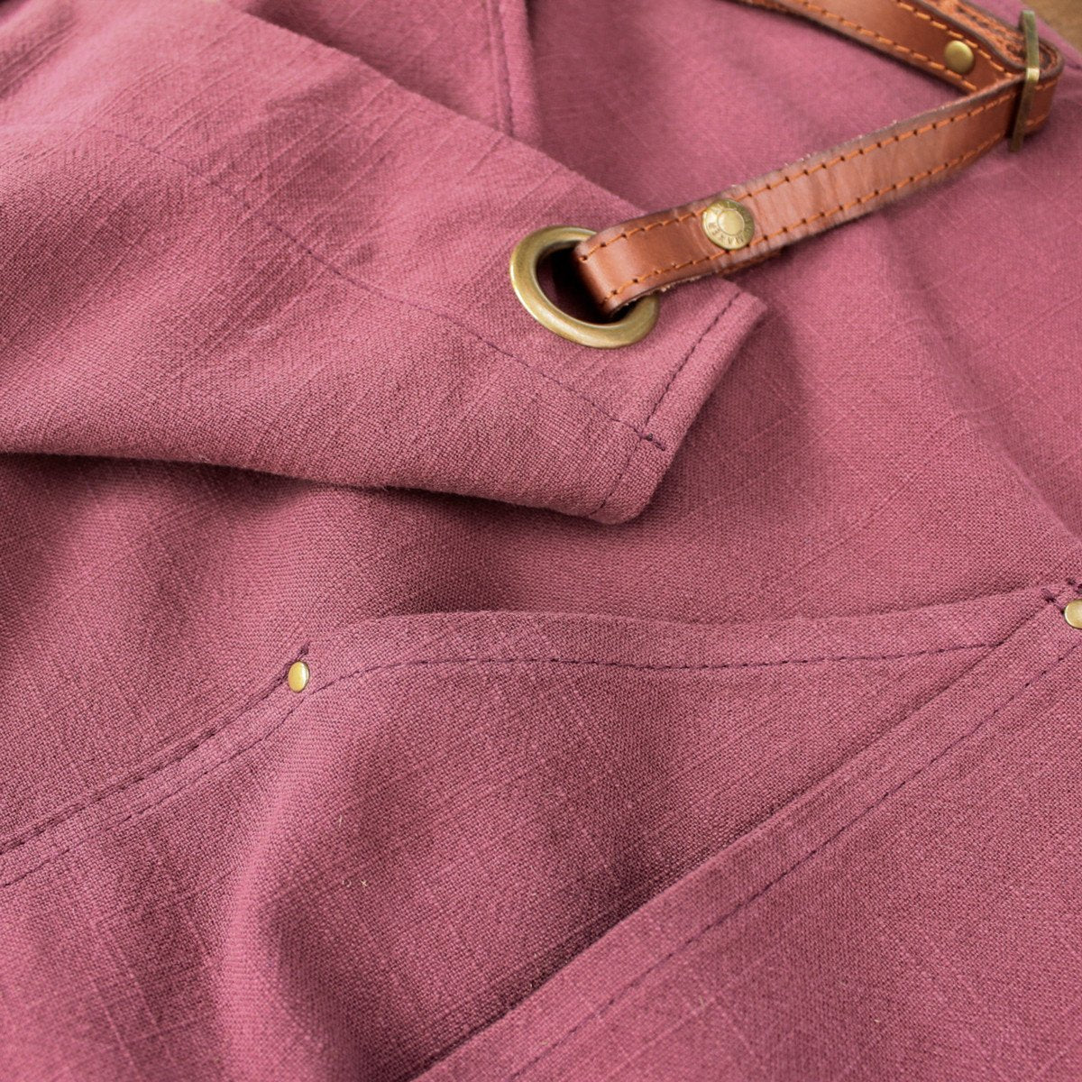Beautiful Burgundy linen Apron Close up of Pocket and Leather Straps 