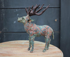 Reindeer Paper Mache With red and green patterned bodies outside HomeStreetHome Shop