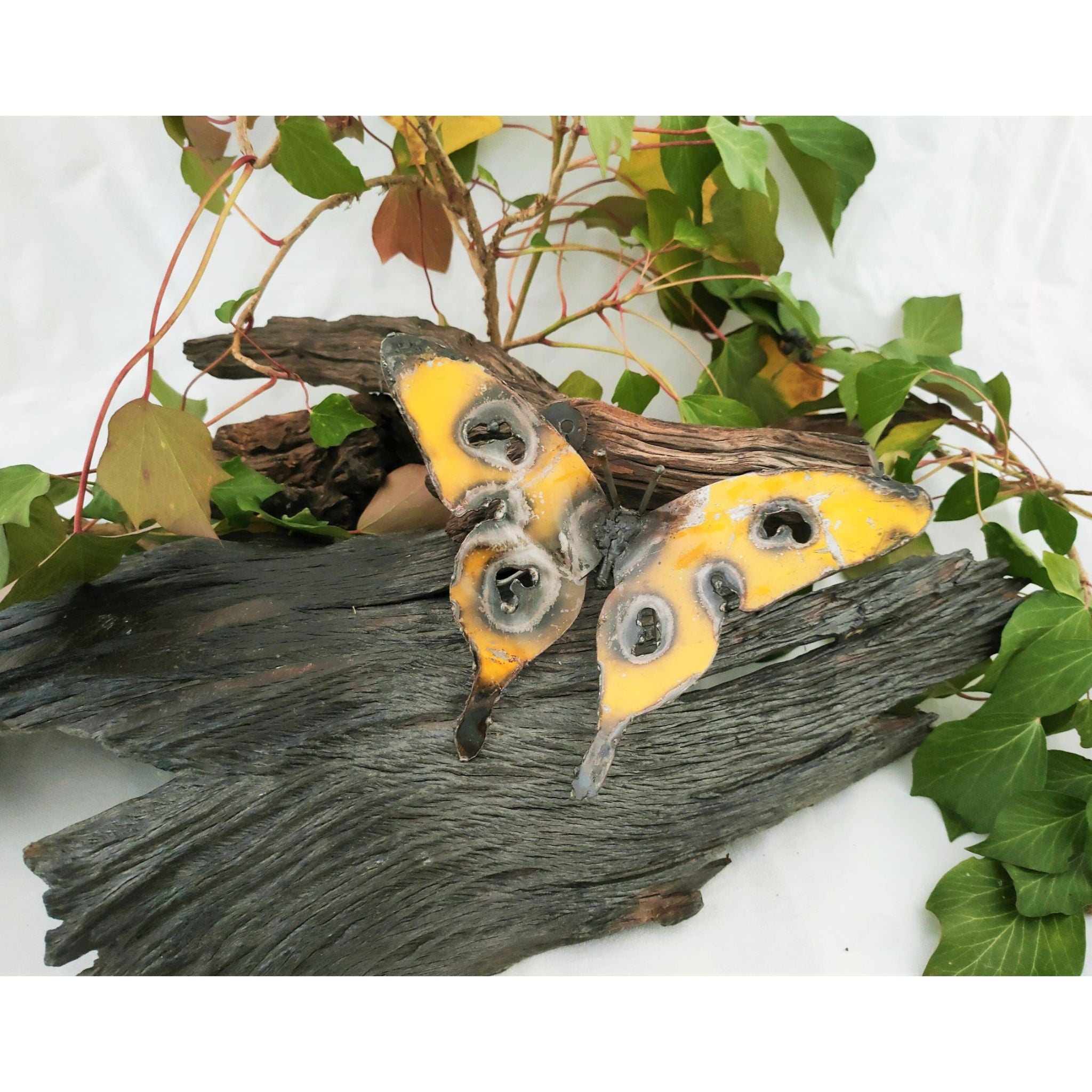 Jeff Butterfly Recycled Metal yellow colour on log
