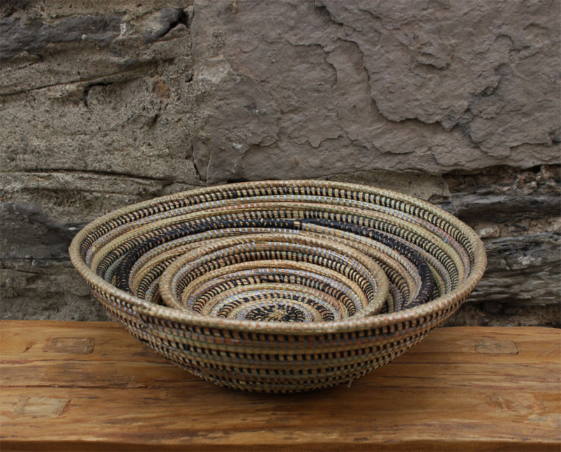 handcrafted round baskets. Three sizes made with recycled plastic and straw. Stacked set of three. Black, grey, and white.